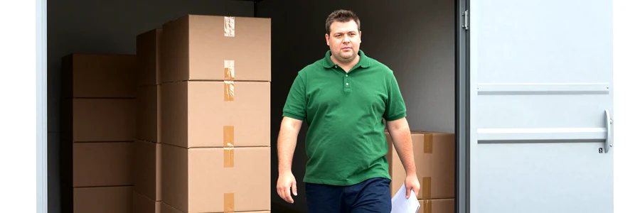 Déménageur professionnel devant un box de stockage ouvert dans un garde-meuble près de Marseille